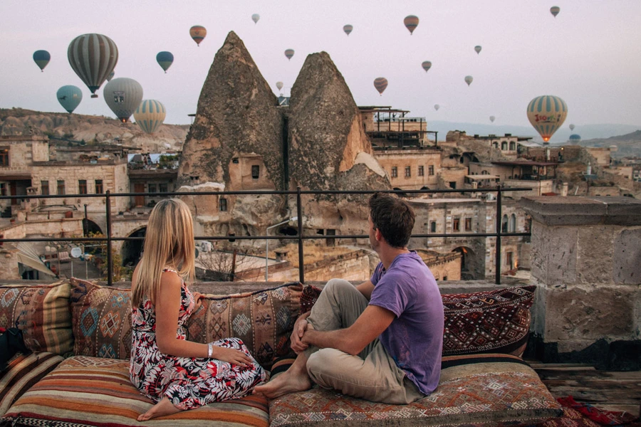 Couple on a background of flying balloons at sunrise in cappadocia
